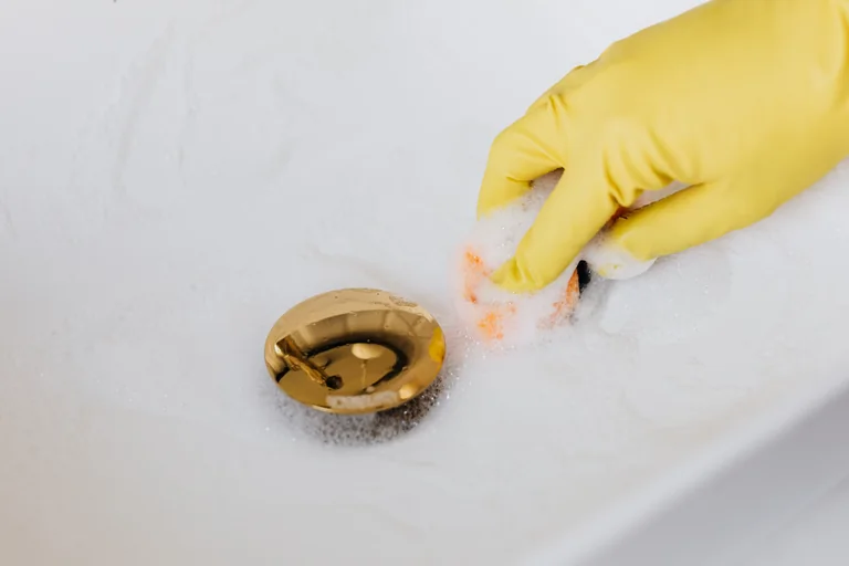 Gloved hand inspecting and cleaning a bathroom surface